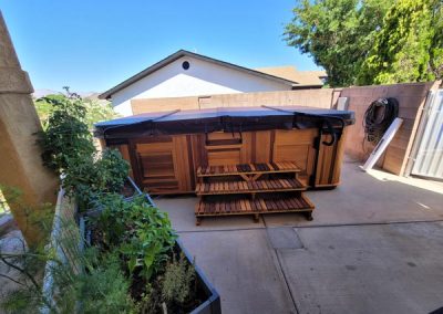 covered all weather pool arctic spas in red cedar cabinet in the backyard